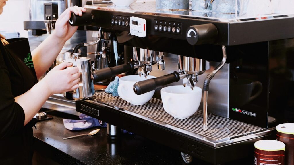 Barista holding a portafilter at a professional cafe espresso machine