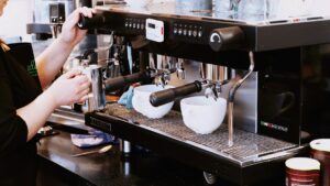Barista holding a portafilter at a professional cafe espresso machine