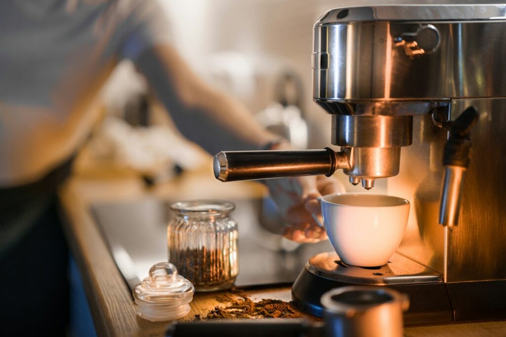 Espresso machine preparing coffee with cup in foreground