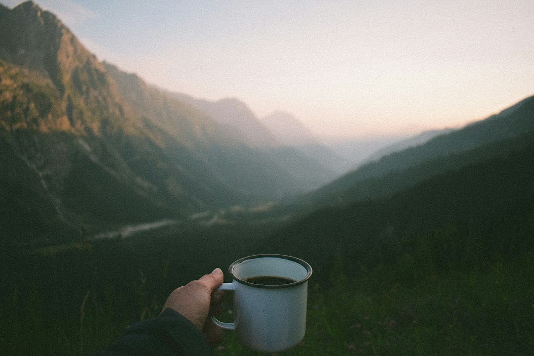 A cup of coffee enjoyed outdoors with a scenic mountain view