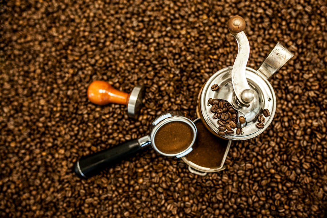 Overhead view of a coffee grinder next to an espresso cup