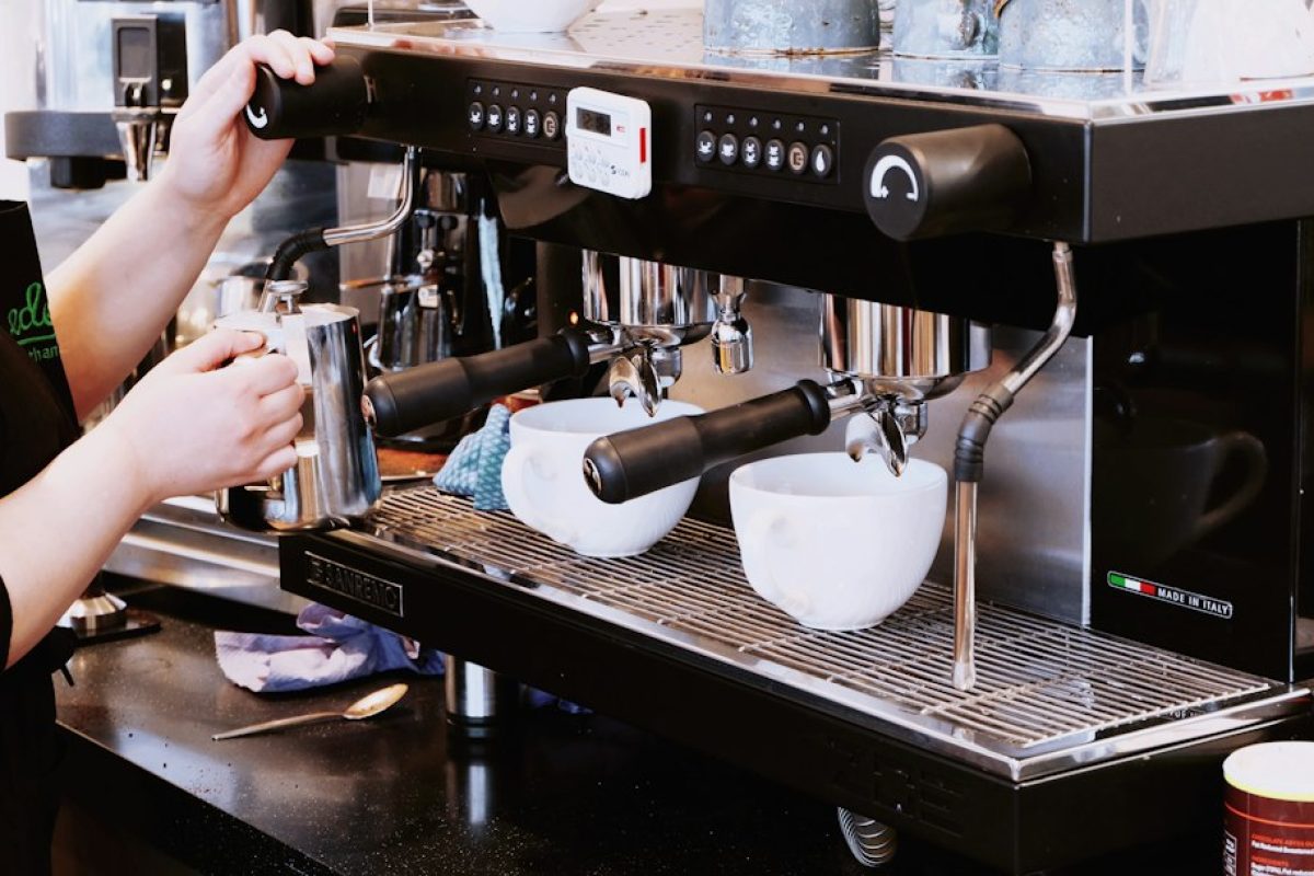 Barista holding a portafilter at a professional cafe espresso machine